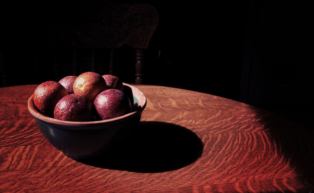 Bowl of blood oranges in sunlight